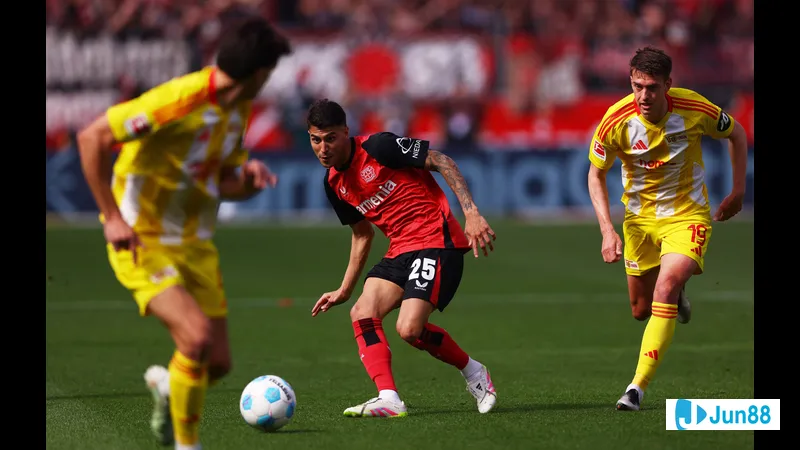 Cầu thủ của Bayer Leverkusen dũng cảm chống chọi với cầu thủ đối phương trong trận đấu với…