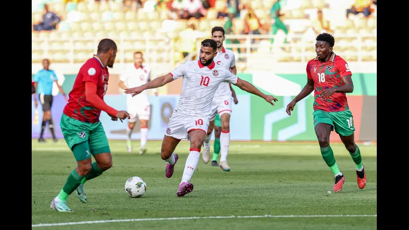 Cầu thủ Tunisia chạy nhanh với bóng trước sự áp đảo của hậu vệ Namibia Cầu thủ Tunisia chạy nhanh với bóng trước sự áp đảo của hậu vệ Namibia